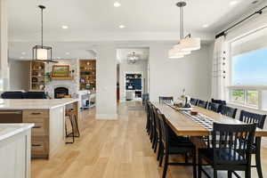 Dining room with large window, recessed lighting, and light wood-style floors