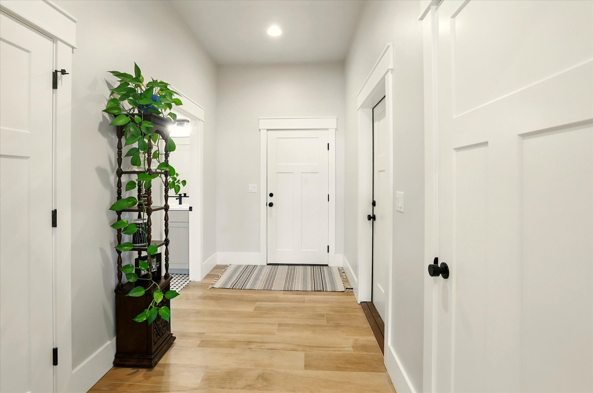 Hallway with light wood-style floors and recessed lighting