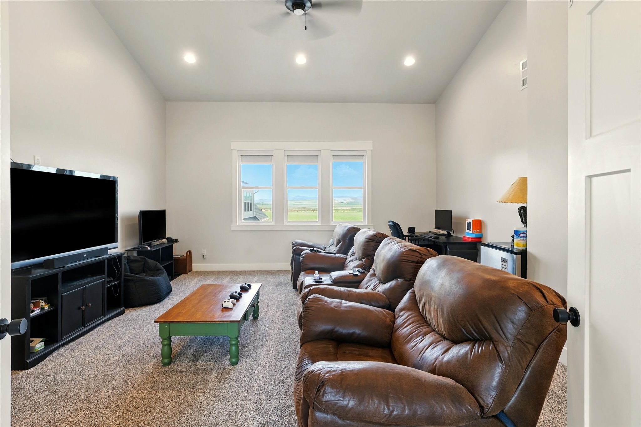 Media room with ceiling fan, a desk, and recessed lighting