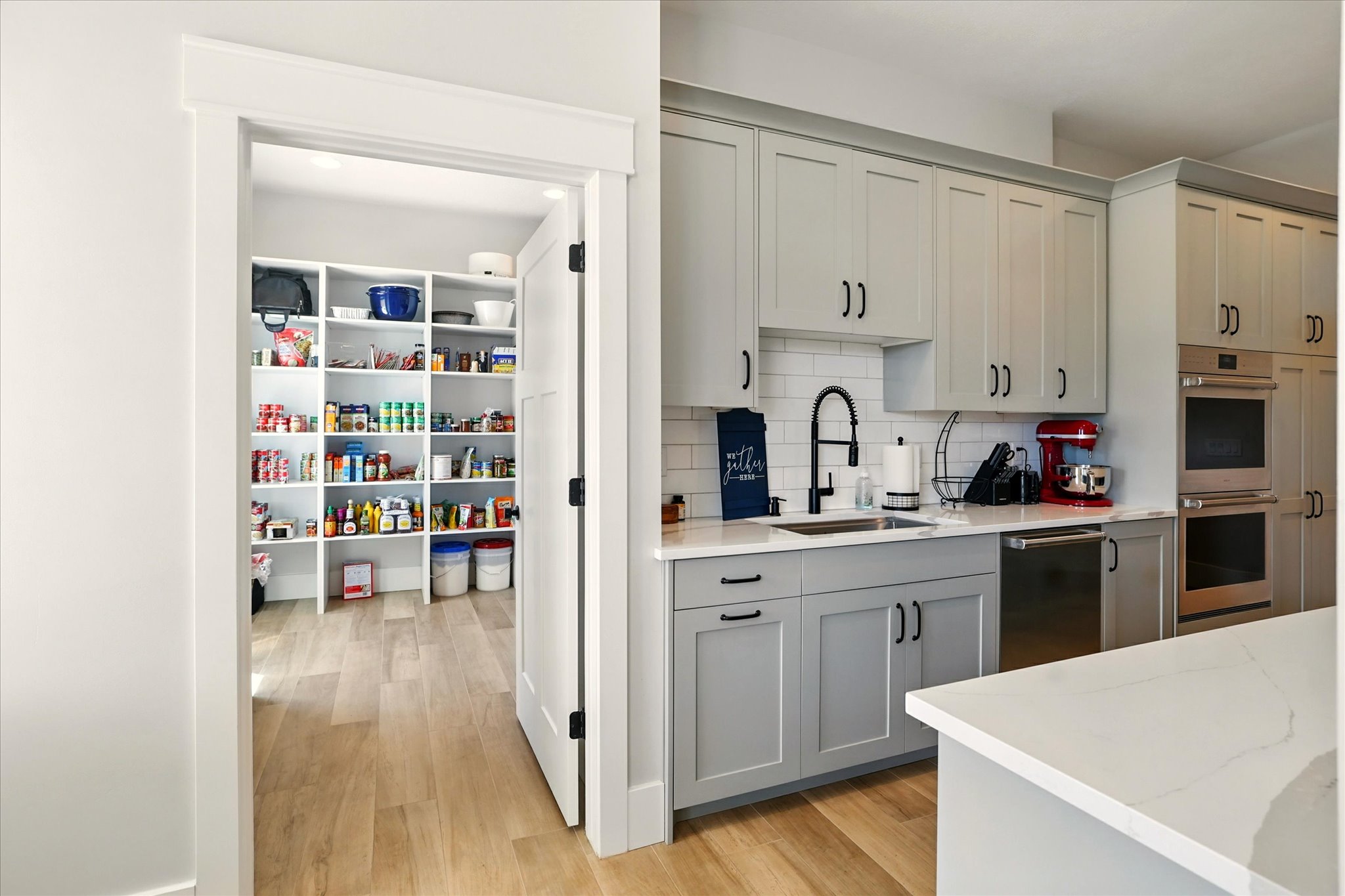Prep-Kitchen with decorative backsplash, light wood-style flooring, gray cabinets, appliances with stainless steel finishes, and light stone counters