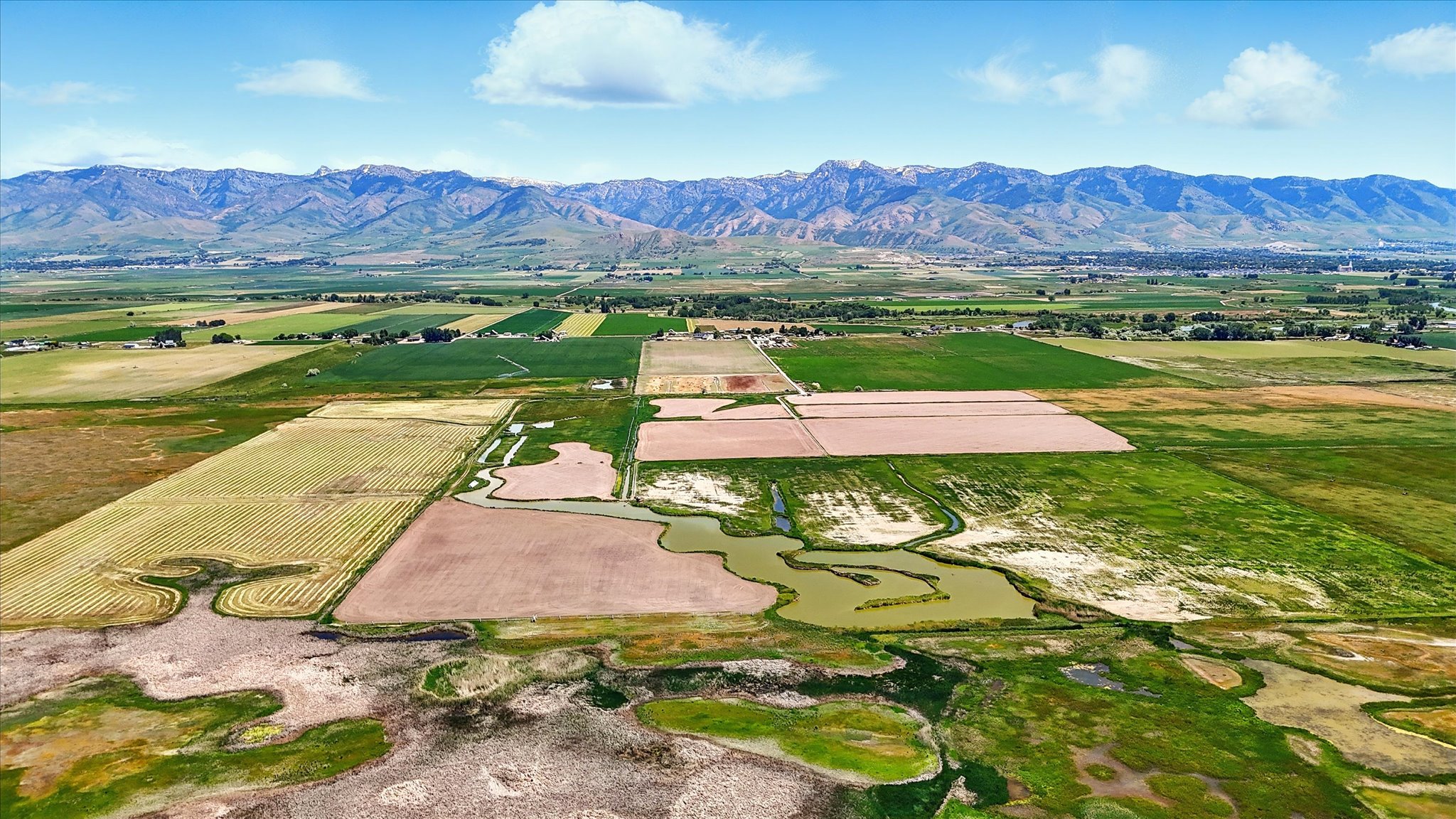 Overview of rural landscape featuring farmland and a water and mountain view