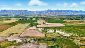 Overview of rural landscape featuring farmland and a water and mountain view