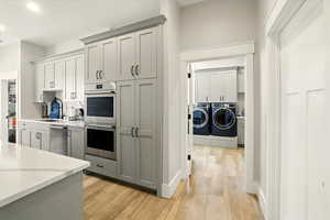 Prep-Kitchen with stainless steel appliances, light wood-style flooring, gray cabinets, separate washer and dryer, and recessed lighting
