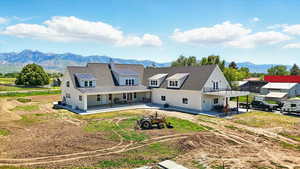 Back of property with a mountain view, a patio, and a chimney
