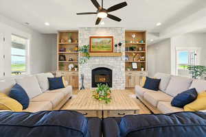 Living area featuring a fireplace, recessed lighting, a ceiling fan, and wood-style floors