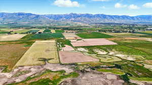 Aerial view of sparsely populated area featuring farmland and a mountainous background