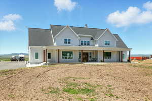 View of front facade featuring covered porch, roof with shingles, a mountain view, and a chimney