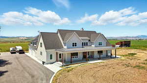View of front of house with roof with shingles, a mountain view, covered porch, driveway, and a chimney