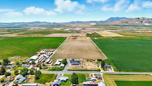 Aerial view of area with a mountainous background and farmland