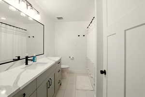 Full bathroom featuring light tile patterned floors, curtained shower, and vanity