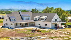 Back of house with a patio, a mountain view, a chimney, and a metal roof