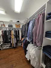 Walk in closet featuring dark wood finished floors