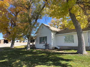 View of side of property featuring a yard, a shingled roof, and crawl space