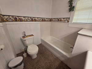 Bathroom with a bath and wainscoting