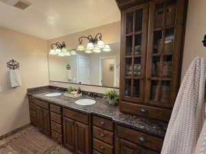 Full bath featuring double vanity, a textured ceiling, and tile patterned flooring