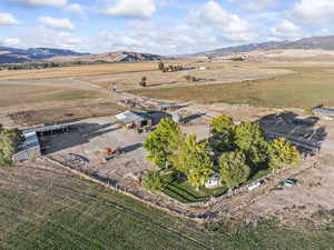 Aerial view of property and surrounding area with a mountainous background and rural landscape