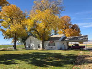 View of side of property featuring a lawn and a carport