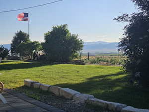 View of grassy yard featuring a mountain view and a view of countryside