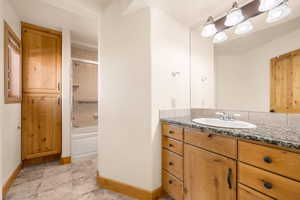 Full bath with vanity, washtub / shower combination, and light tile patterned floors