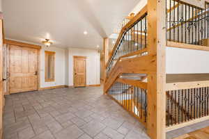 Entrance foyer with recessed lighting, stairway, and stone tile floors
