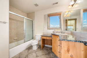 Bathroom featuring vanity, enclosed tub / shower combo, and light tile patterned floors