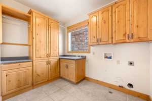 Washroom featuring cabinet space, hookup for a washing machine, hookup for an electric dryer, and hookup for a gas dryer