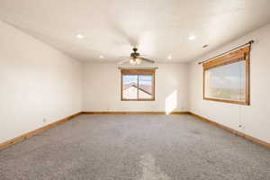 Empty room with light carpet, a textured ceiling, recessed lighting, and ceiling fan