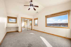 Unfurnished bedroom featuring lofted ceiling, carpet floors, ceiling fan, and a closet