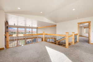 Carpeted empty room featuring vaulted ceiling, recessed lighting, and a mountain view