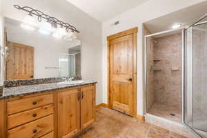Bathroom featuring vanity and a stall shower