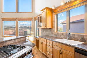 Kitchen featuring backsplash, healthy amount of natural light, gas stove, and light wood finished floors