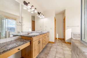 Full bathroom featuring double vanity, a stall shower, light tile patterned flooring, and a tub to relax in