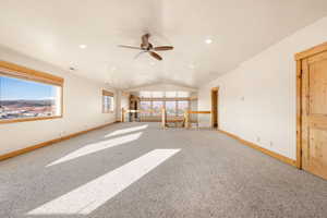 Unfurnished living room with vaulted ceiling, carpet, ceiling fan, and recessed lighting