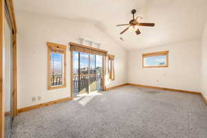 Empty room featuring carpet flooring, a ceiling fan, and high vaulted ceiling