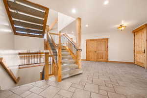Stairway featuring stone tile floors and recessed lighting