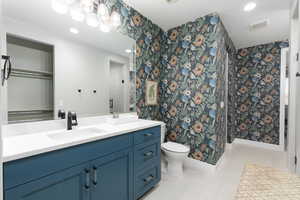 Full bath featuring wallpapered walls, vanity, light tile patterned floors, a stall shower, and recessed lighting