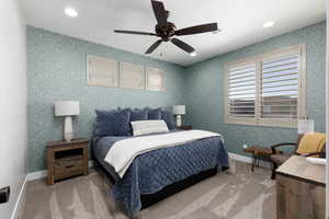 Carpeted bedroom featuring wallpapered walls, a ceiling fan, and recessed lighting