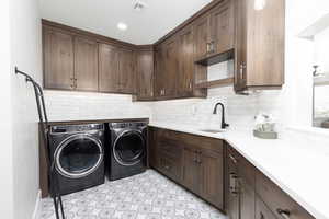 Laundry room with washer and clothes dryer, cabinet space, and recessed lighting