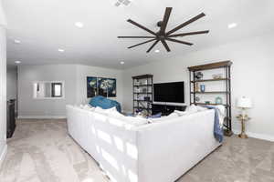 Carpeted living room featuring recessed lighting and ceiling fan
