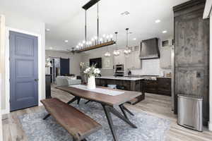 Dining area with a barn door, light wood-style flooring, and recessed lighting