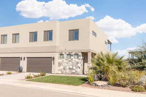 View of front facade with driveway, stucco siding, and an attached garage