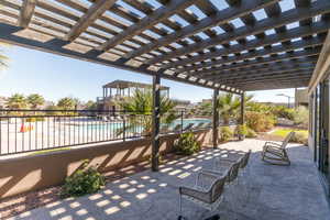 View of patio / terrace featuring a community pool and a pergola