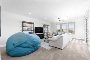 Living room featuring light colored carpet, recessed lighting, and a ceiling fan
