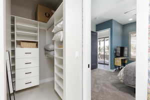 Spacious closet featuring light colored carpet