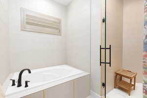 Full bath with a garden tub and tile walls