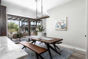 Dining area featuring light wood-type flooring and a chandelier