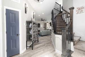 Foyer entrance with stairway, light wood-type flooring, recessed lighting, and ceiling fan