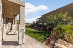 View of green lawn with a patio area