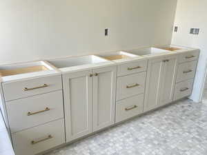 Kitchen featuring white cabinetry and light countertops