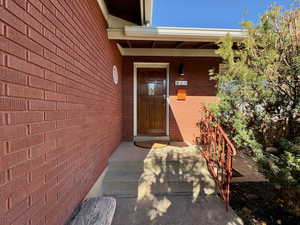 View of exterior entry featuring brick siding